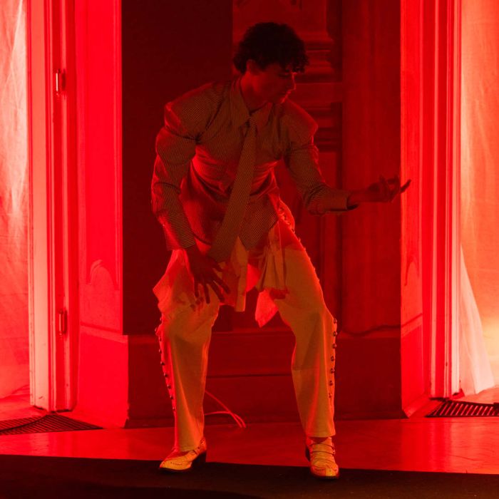 Eine Person tanzt - und ist in rotes Licht getaucht.