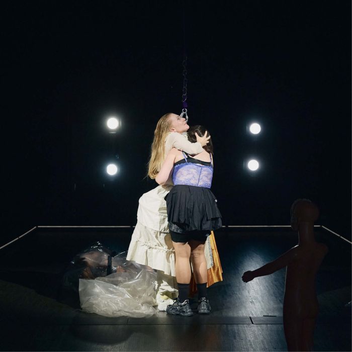 Zwei PErsonen umarmen sich, eine trägt ein historisches Kostüm.