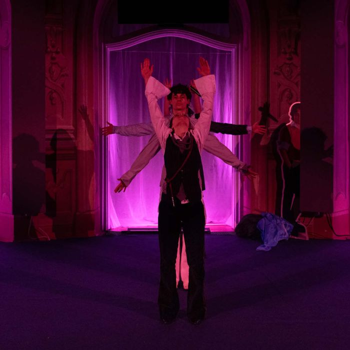 Eine Tanzszene mit 4 Personen, das Licht ist Pink.