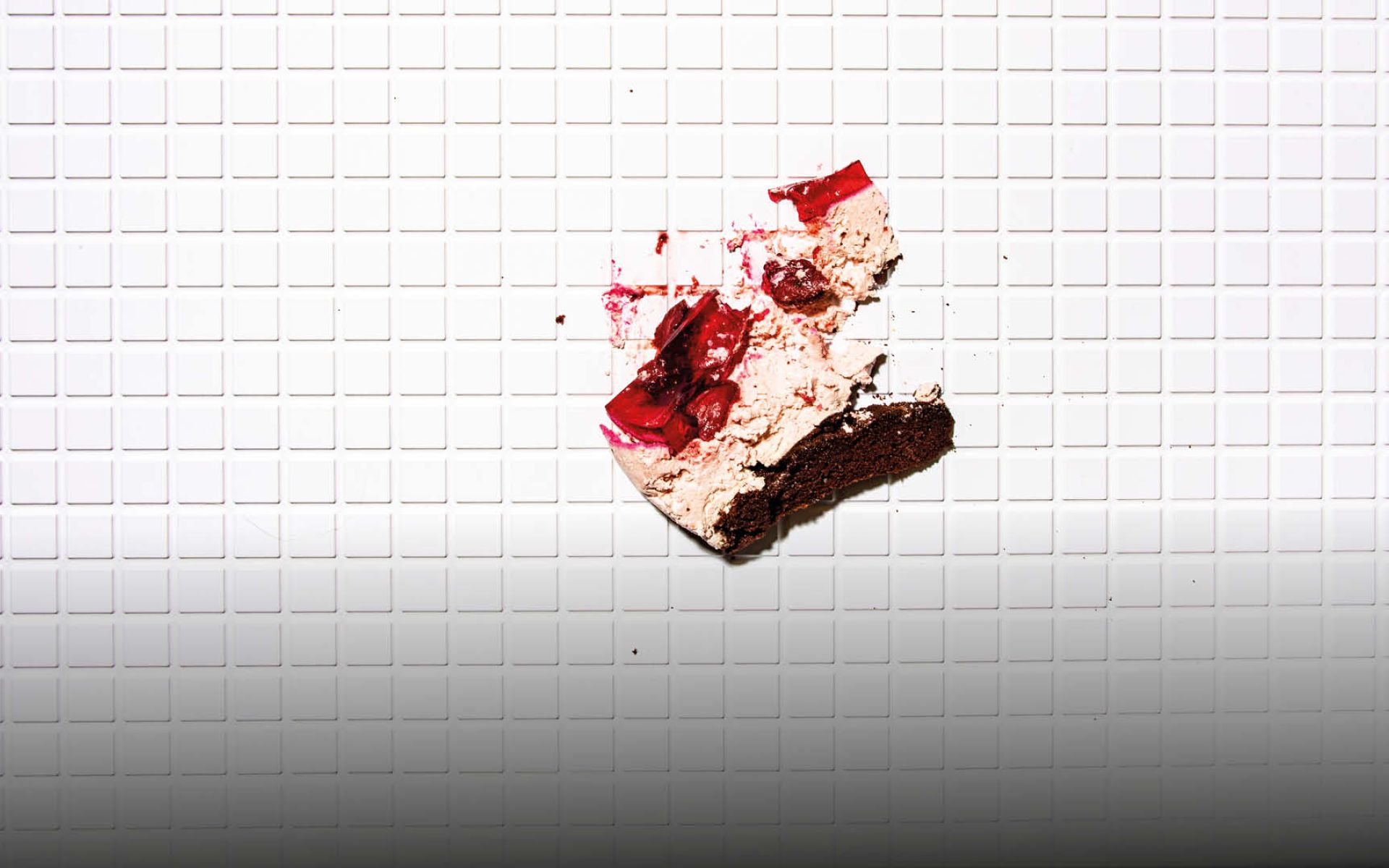 Bild einer Torte, die an eine geflieste Wand geworfen wurde.